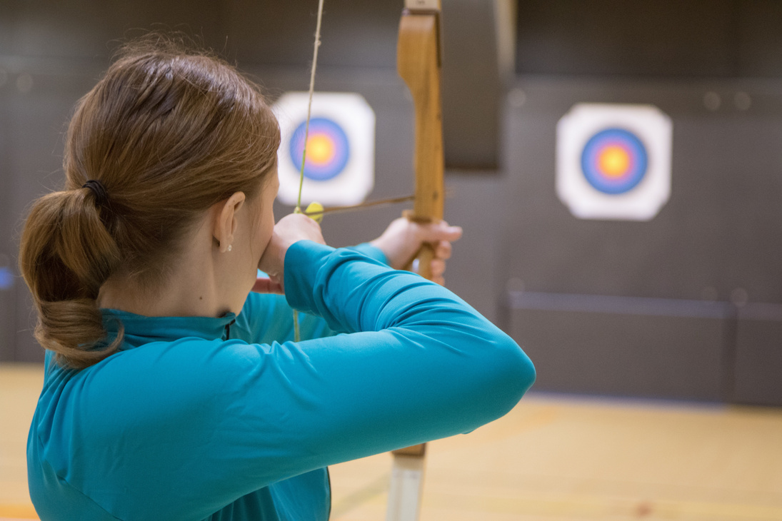 Woman Practicing Archery Indoors